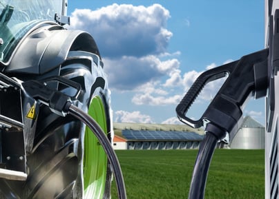 Ladestation für Elektrofahrzeuge auf einem Hintergrund eines landwirtschaftlichen Traktors