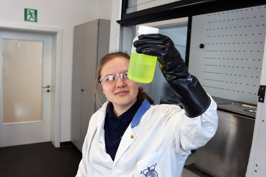 Auszubildende Physiklaborantin betrachtet Chemikalische Flüssigkeit