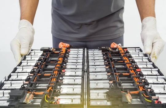 Hände in Handschuhen von Technikexperten Elektroauto, EV-Auto beim Öffnen einer Lithium-Ionen-Autobatterie
